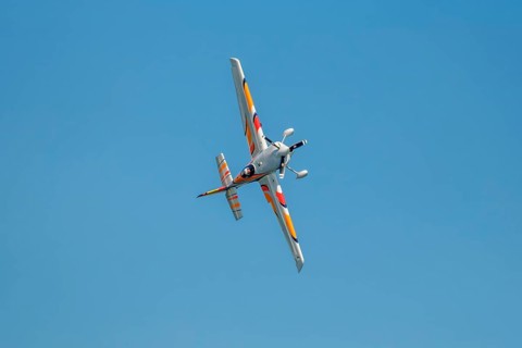 Stunt aerobatic plane performing stunts in blue sky. Concept of speed, difficulty, precision, risk,