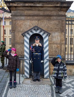 Two children salute next to the castle guard, Prague, Czech Republic, Europe