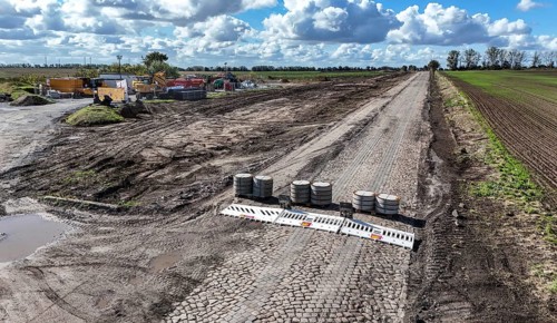 Construction vehicles are parked at an access road under construction to the High Tech Park at the