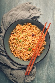 Instant noodles, in a bowl, on a gray table, top view, no people