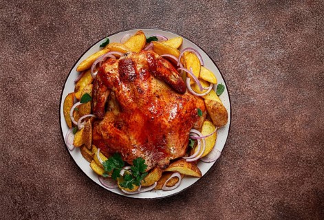 Fried, baked chicken, in the oven, with spices, and rustic potatoes, top view, homemade