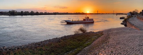 Sunset over river Rhine Lower Rhine, in the centre small passenger ferry two-wheel ferry Rees, on