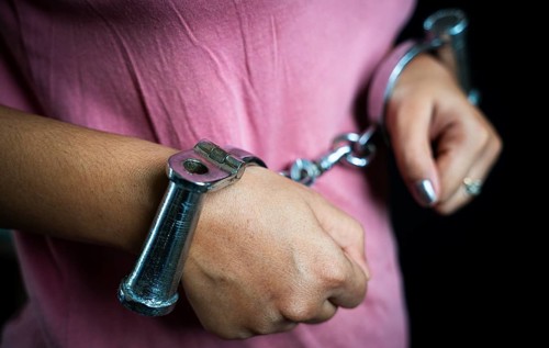 Woman hands in handcuffs- concept image