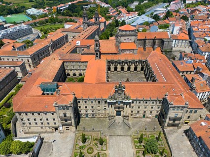 A large historic monastery building with a central courtyard and orange-coloured roofs, aerial
