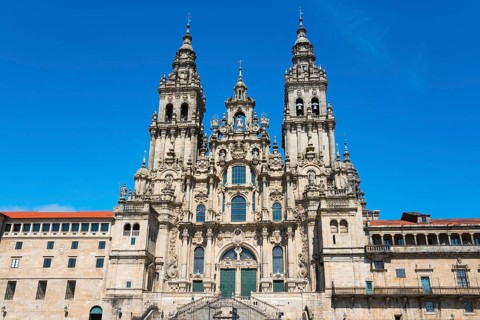 Impressive baroque cathedral with two towers and elaborate façade under a clear blue sky,