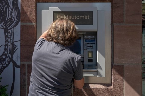 Man withdrawing money from an ATM, Nuremberg, Middle Franconia, Nuremberg, Germany, Europe