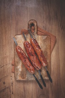 Fried sausages, in English with bacon, for grilling, on a cutting board, top view, no people