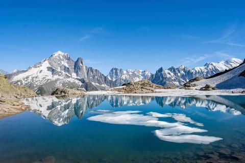 Mountain landscape with mountain lake and ice floe, water reflection in Lac Blanc, mountain peak,