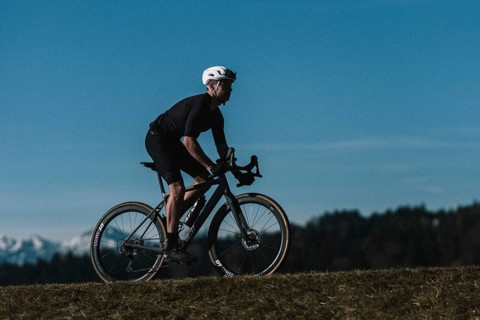 Road bike rider in spring near Halblech in the Allgäu in front of a picturesque backdrop of the