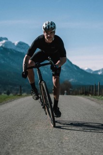 Road bike rider in spring near Halblech in the Allgäu in front of a picturesque backdrop of the
