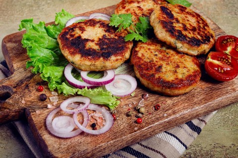 Fried chicken cutlets, minced chicken, with vegetables, on a cutting board, with vegetable salad,