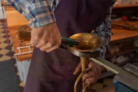Metal instrument maker dents the bell of a trumpet, Magdeburg, Saxony-Anhalt, Germany, Europe