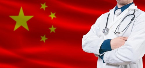 China Health Care concept. Male doctor on China flag. Doctor with crossed arms on China flag