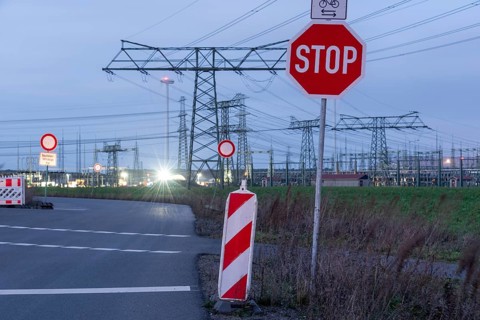 Road with stop sign and high-voltage pylons in the background, evening mood, Wolmirstedt,