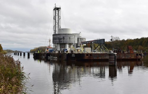 Tugboat towing a pontoon with offshore installation in the Kiel Canal, Schleswig-Holstein, Germany,