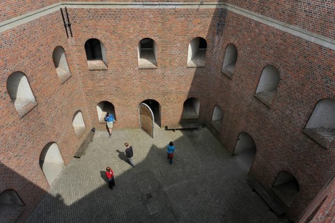 Tourists with audio guides visiting the pentagonal courtyard of Fort Napoleon in Ostend, Belgium,