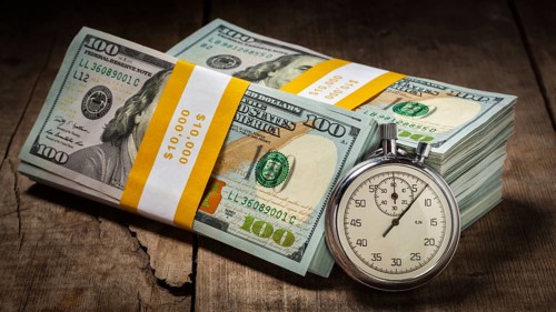 Time is money loan concept background, panorama of stopwatch and stack of new 100 US dollars 2013