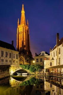 Church of Our Lady and canal illuminated in the night. Brugge Bruges, Belgium, Europe