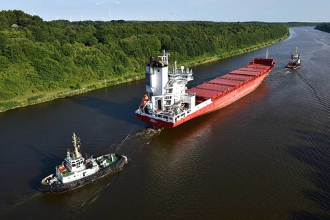 Cargo ship Nova being towed by tugs in the Kiel Canal, Schleswig-Holstein, Germany, Europe