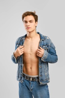 Young man in denim clothes ober naked body