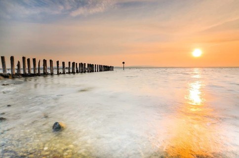 Golden sunrise on the shore of Lake Constance with jetty near Altnau in the canton of Thurgau,