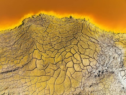 Cracked earth at the bank of the Rio Tinto (Red river) with its deep reddish hue due to oxidised