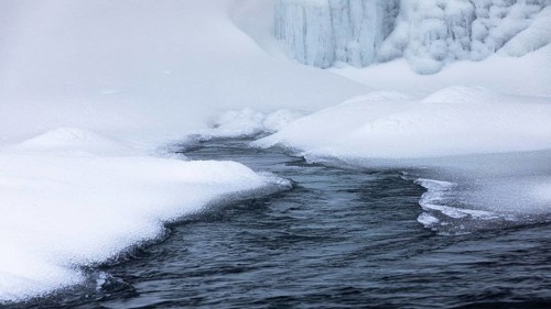 Snow mounds and icicles in the Skoga River below Skogafoss waterfall, Sudurland, Iceland, Europe
