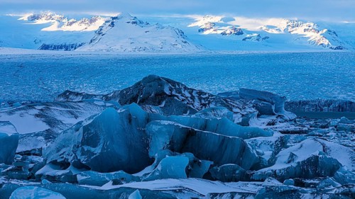 Snow-covered icebergs in the glacier lagoon Jökullsarlon, Breidamerkurjökull in the background,
