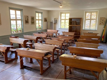Historic classroom with old-fashioned school desks for school class in village school in old