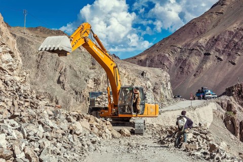 LADAKH, INDIA, SEPTEMBER 10, 2011: Excavator cleaning road after landslide in Himalayas. Ladakh,
