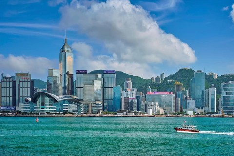 HONG KONG, CHINA, MAY 1, 2018: Boat in Victoria Harbour and Hong Kong skyline cityscape downtown