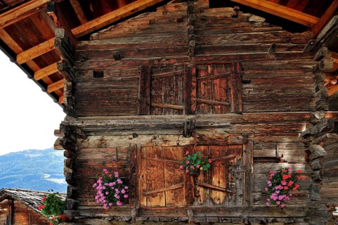 Traditional wooden granary decorated with geraniums in the alpine village of Grimentz, Valais,