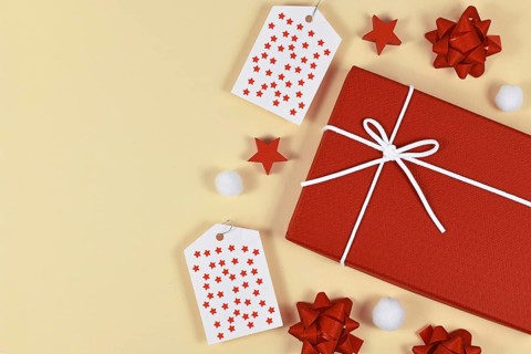 Christmas present gift wrapping concept with red gift box, ribbons, gift labels and white snow