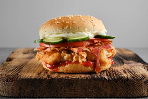 Chicken fresh burger with bacon and fresh cucumber, front view