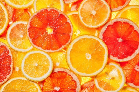Colorful citrus fruit, lemon, orange, grapefruit, slices background. Backlit