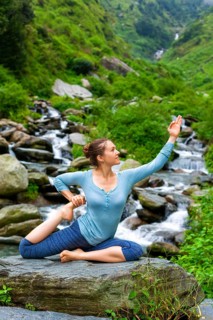 Hatha yoga outdoors, young sporty fit woman doing yoga asana Eka pada rajakapotasana, one-legged