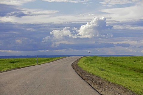 Empty road and rain clouds forming over the Gobi desert, rain shadow desert turning green in