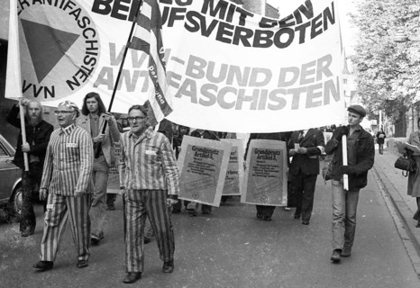 Nazi victims, some in concentration camp uniforms, demonstrated against the occupational bans