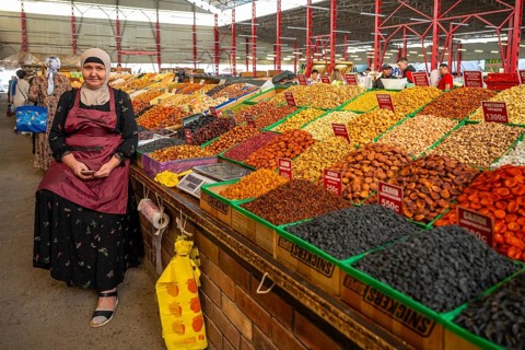 Vendor selling sweets, dried fruit and nuts, market stall at the Osh Bazaar, Bishkek, Kyrgyzstan,