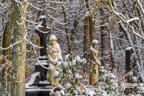 Graves with stone sculptures of mourning woman in the snow, Südwest-Kirchhof, historic cemetery in