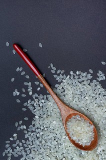 Rice, white rice grains in wooden spoon