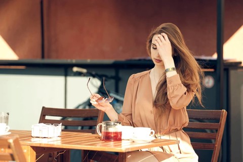 Beautiful young woman has coffee break in the middle of sunny day