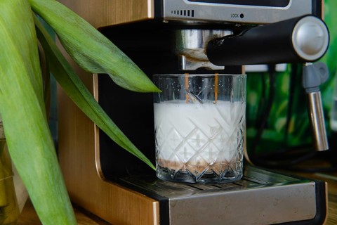 Closeup view of making cappuccino in coffee machine at home