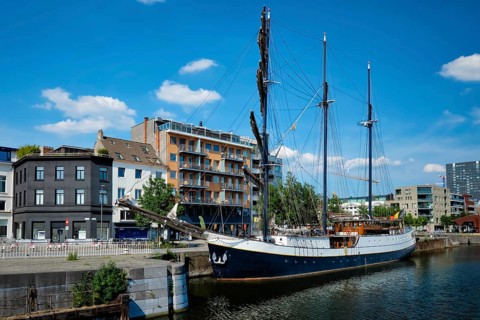 Ship moored in Willemdock in Antwerp. View of Bonapartedok harbor and vintage galleon. Antwerpen,