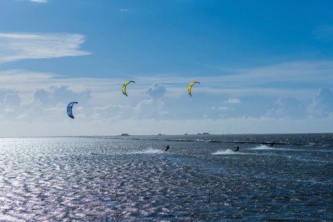 Kitesurfing on the North Sea, Lüttmoorsiel, Reußenköge, on the horizon Hallig Nordstrandischmoor,
