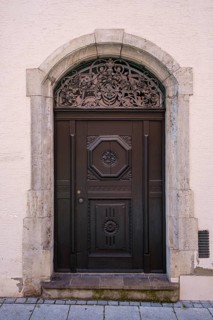 Artfully crafted round-arched door in a historic building on Manghausplatz in the old town of