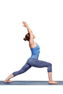 Beautiful sporty fit yogini woman practices yoga asana Virabhadrasana 1, warrior pose 1 isolated on