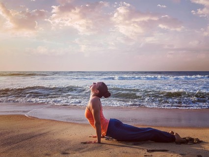 Yoga outdoors, woman doing Ashtanga Vinyasa yoga Surya Namaskar Sun Salutation asana Urdhva Mukha