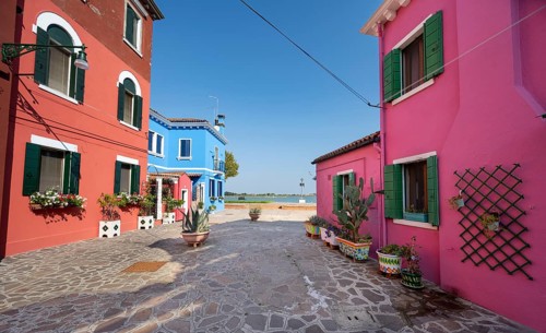 Colourful houses with flowers and clothesline, colourful house facades, alleys on the island of