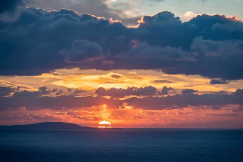 Dramatic cloudy sky at sunrise over the sea, Aegean Sea, Syros, Cyclades, Greece, Europe